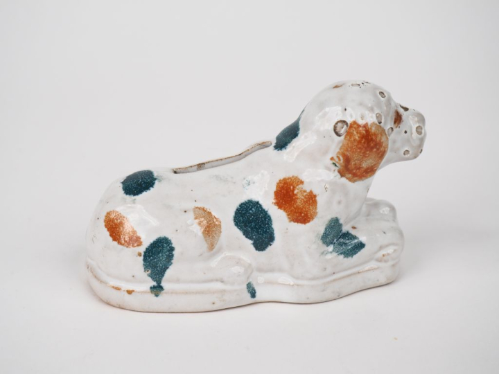 Tirelire en faïence polychrome en forme de chien assis. Dim. 9 x 14 x 