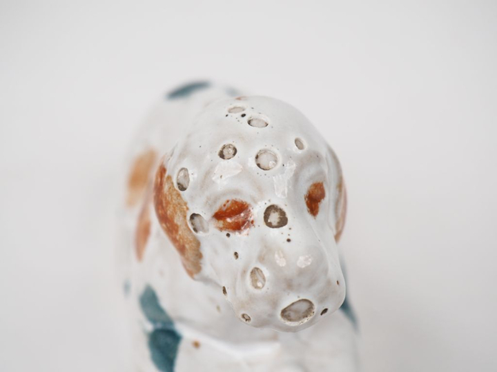 Tirelire en faïence polychrome en forme de chien assis. Dim. 9 x 14 x 