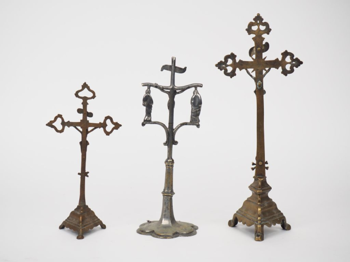 Trois différents crucifix anciens en bronze et bronze argenté.  H. de 