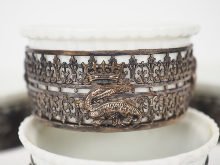 Huit casserolettes en porcelaine, monture ajourée en métal argenté à d