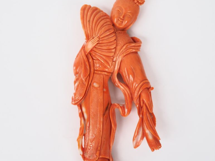 Chine vers 1940. Statuette en corail orangé figurant une jeune fille à