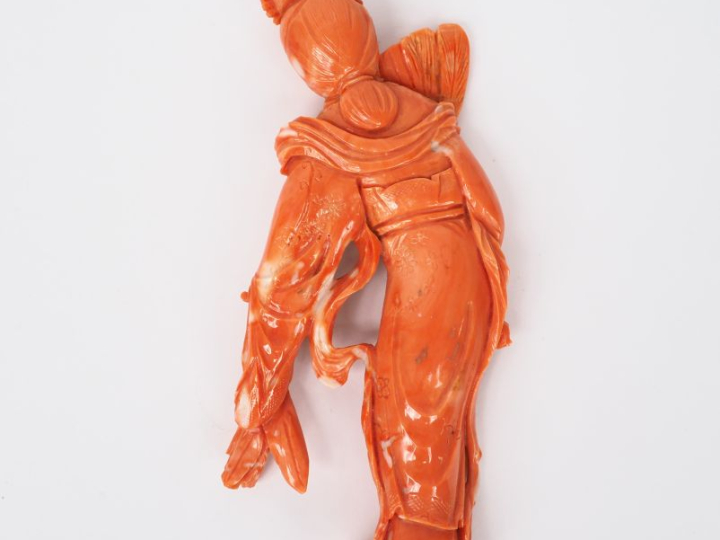 Chine vers 1940. Statuette en corail orangé figurant une jeune fille à