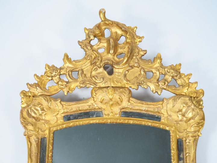 Glace Louis XV à parecloses en bois et stuc doré, à décor de cartouche