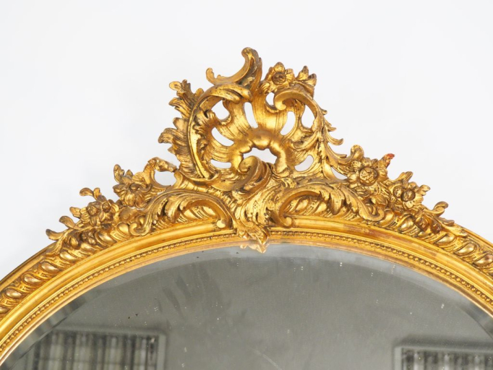Miroir ovale Napoléon III en bois et stuc doré de style rocaille. Dim.