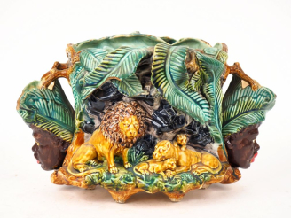 Vente aux enchères Grand cache pot en barbotine, à décor en relief de têtes d'africains e