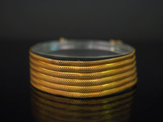 Vente aux enchères Bracelet manchette en or jaune 750, maille plate tressée, à décor de c