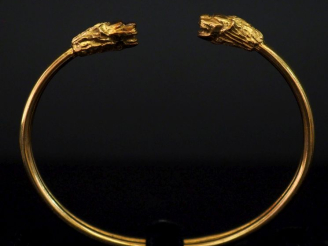 Vente aux enchères Bracelet jonc en or jaune 750, à décor de deux lions affrontés aux ext