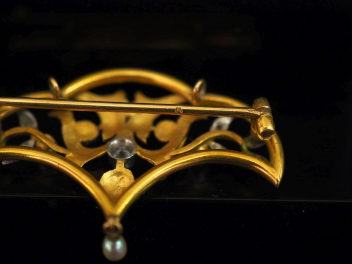 Broche 1900 en or jaune 750, à décor ajouré de feuillage et sertie de 