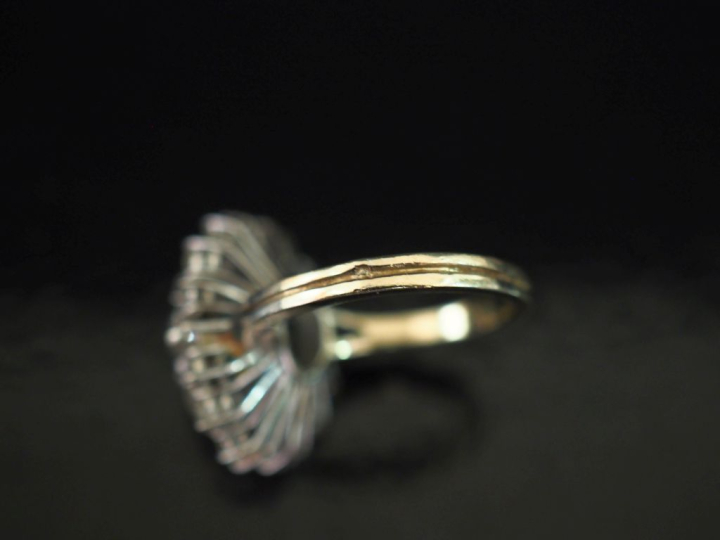 Bague de forme bombée en or blanc 750, sertie en son centre d'une émer