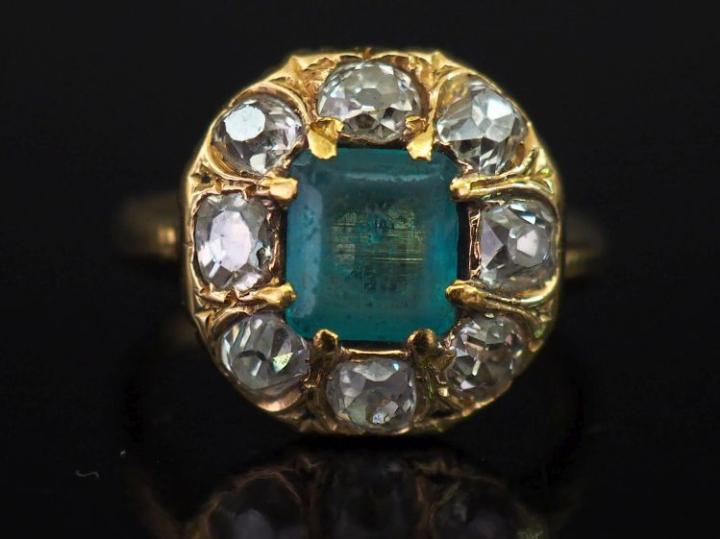 Bague en or jaune 750, sertie en son centre d'une émeraude et entourée