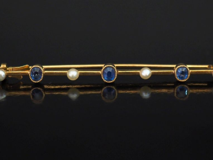 Broche barrette en or jaune 750, sertie de perles et saphirs alternés.