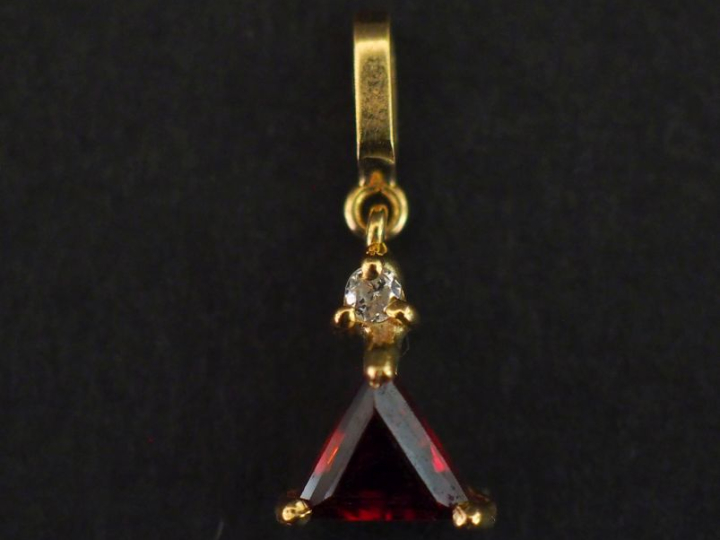 Petit pendentif en or jaune 750, serti en son centre d'une pierre roug