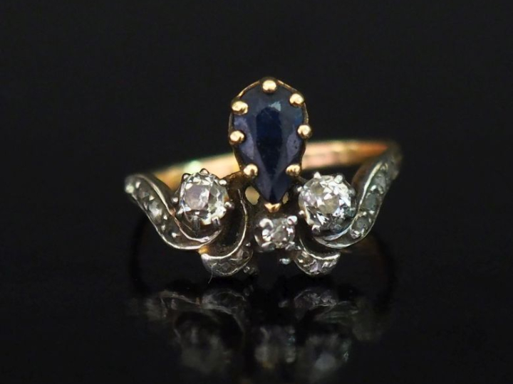 Bague en or jaune 750, à décor d'une fleur de lys sertie d'un saphir e