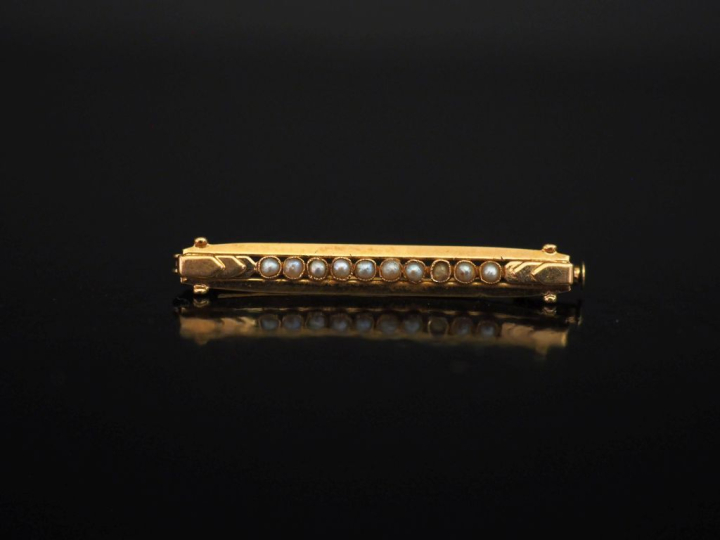 Petite broche barrette en or jaune 750, sertie d'un rang de perles bla