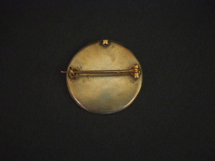 Broche circulaire porte-photo en métal doré et émail blanc.  Pique en 