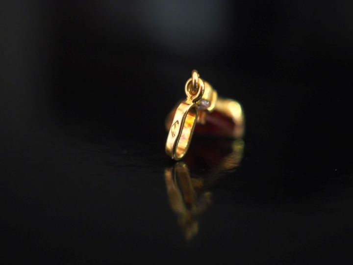 Petit pendentif en or jaune 750, serti en son centre d'une pierre roug
