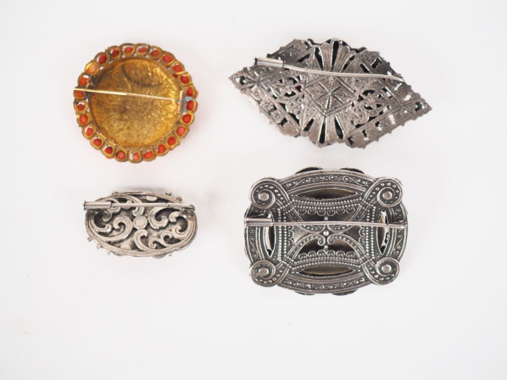 4 différentes broches en métal argenté, émail et cobochons de corail. 