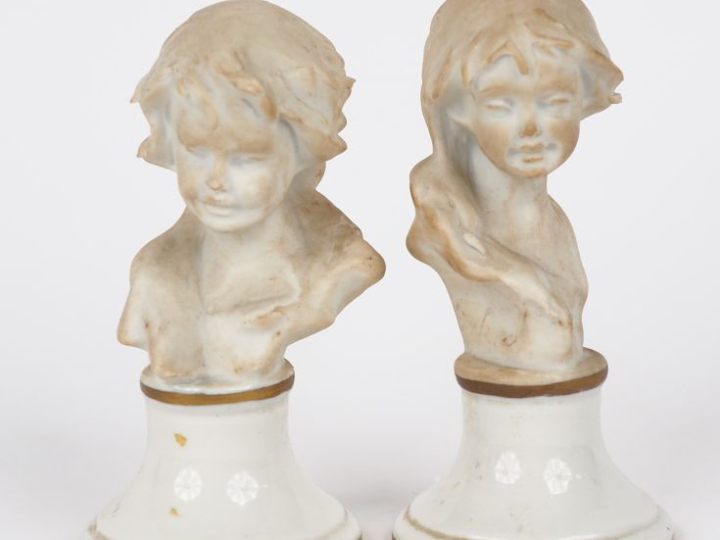 Paire de sujets en biscuit, "bustes d'enfants", sur des socles en porc