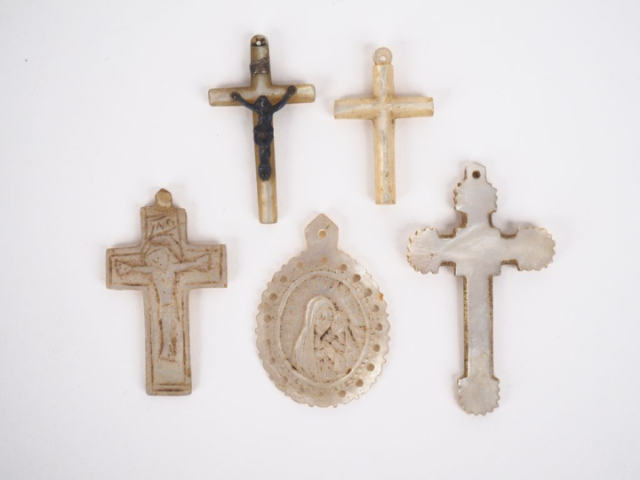 4 différentes croix et une médaille religieuse en nacre. H. de 3 à 4,5