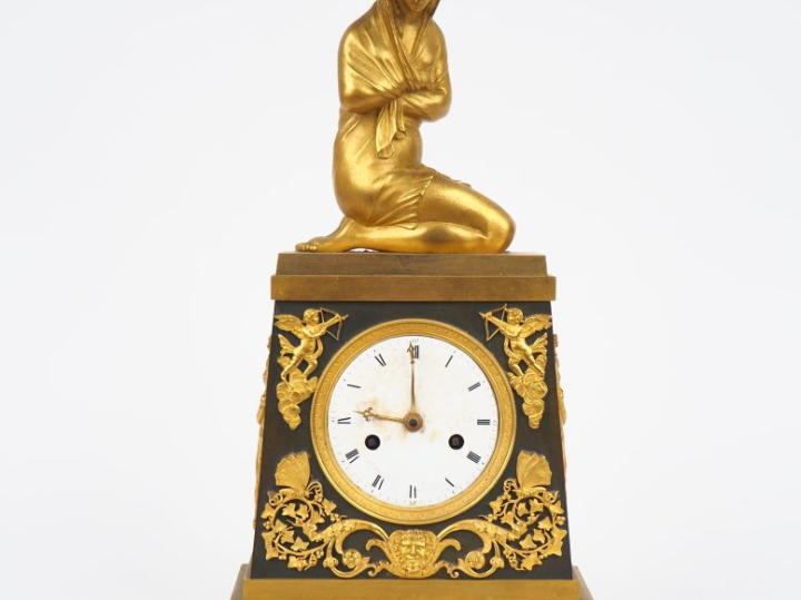 Pendule borne Empire en bronze à patine verte et dorée représentant un