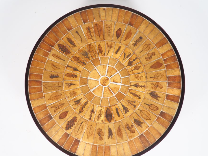 CAPRON.  Table basse circulaire plateau en céramique brune, à décor de