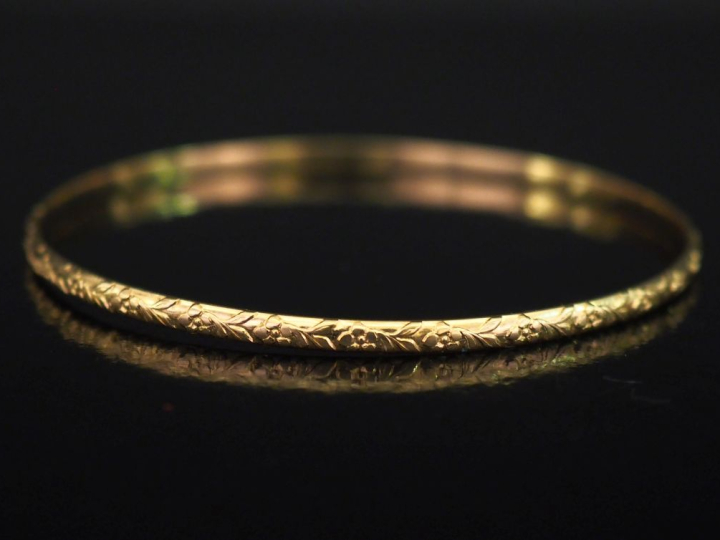 Jonc en or jaune 750, à décor de fleurs et feuillage.  Diam. 6,5 cù Po