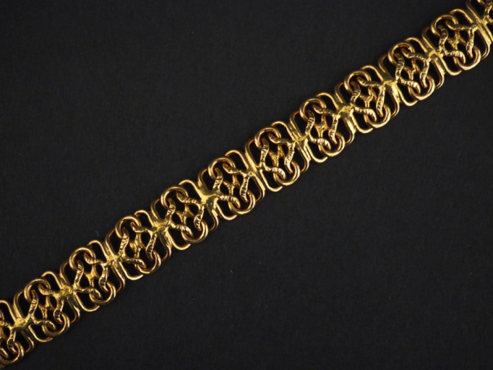 Bracelet souple en or jaune 750, à décor ajouré d'entrelacs.  Larg. 1 