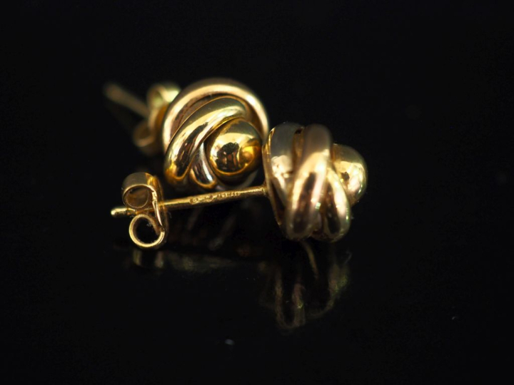 Paire de puces d'oreilles trois tons d'or 750, à décor d'entrelacs.  D