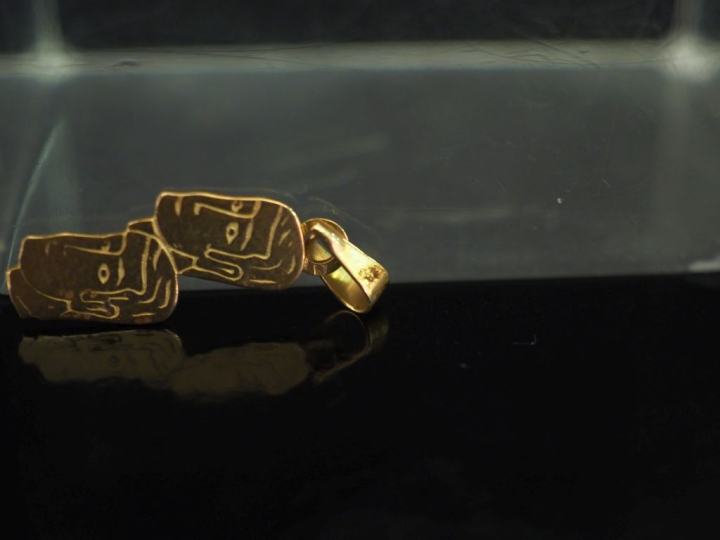 Pendentif en or jaune 750, figurant deux visages d'homme.  H. 1,8 cm (