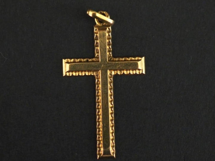 Pendentif en or jaune 750 en forme de croix.  Joli pourtour dentelé.  