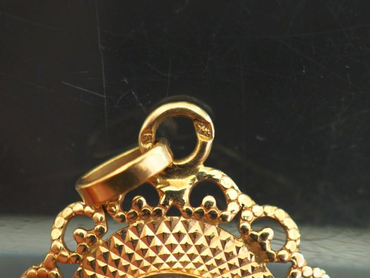 Pendentif ovale en or jaune 750, serti en son centre d'une pierre bleu