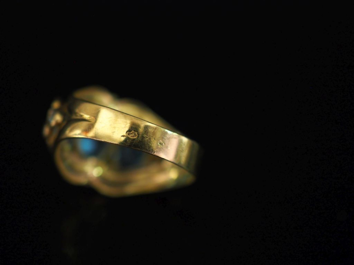 Bague bandeau ajourée en or jaune 750, sertie de trois pierres bleues 