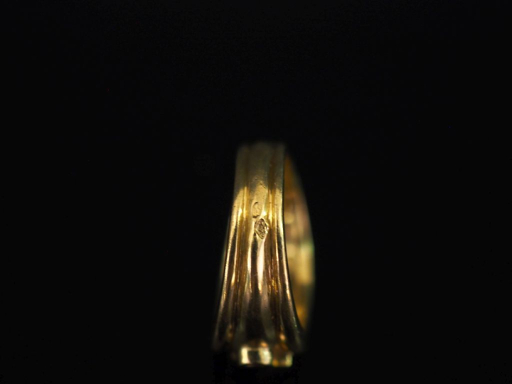 Bague bandeau en or jaune 750, à décor ajouré de feuillage et sertie d