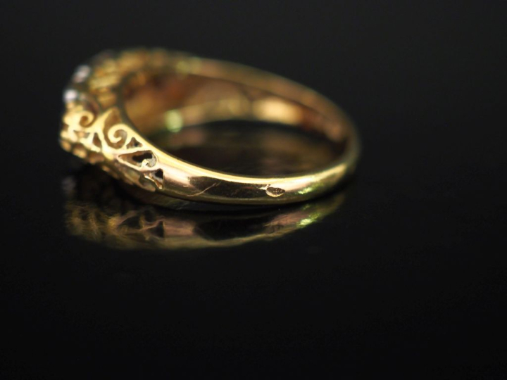 Bague jarretière en or jaune 750, sertie de cinq pierres roses en chut