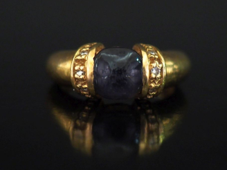 Vente aux enchères Bague en or jaune 750, sertie en son centre d'une pierre bleue en cabo