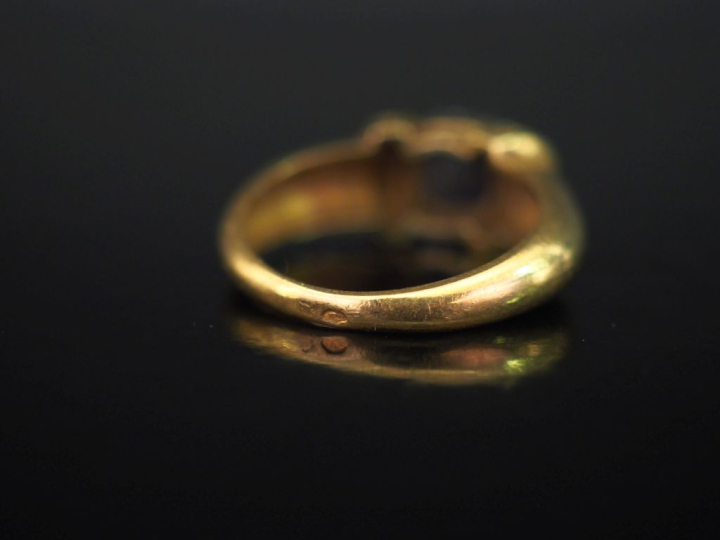 Bague en or jaune 750, sertie en son centre d'une pierre bleue en cabo