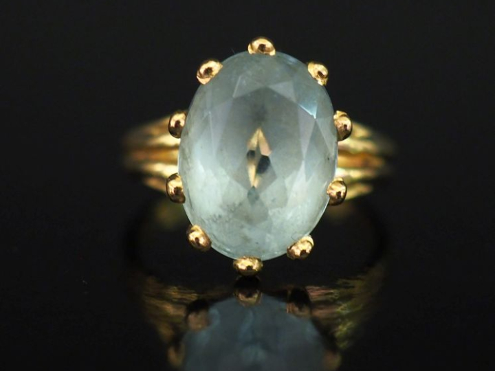 Bague en or jaune 750, sertie en son centre d'une pierre bleu ciel.  T