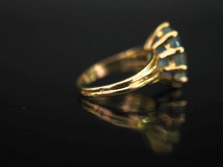 Bague en or jaune 750, sertie en son centre d'une pierre bleu ciel.  T