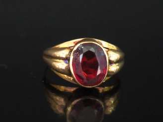 Vente aux enchères Bague en or jaune 750, sertie en son centre d'une pierre rouge.  La mo