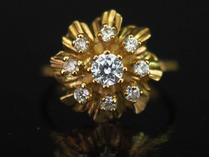 Bague en or jaune 750, ornée en son centre d'un motif de fleur sertie 