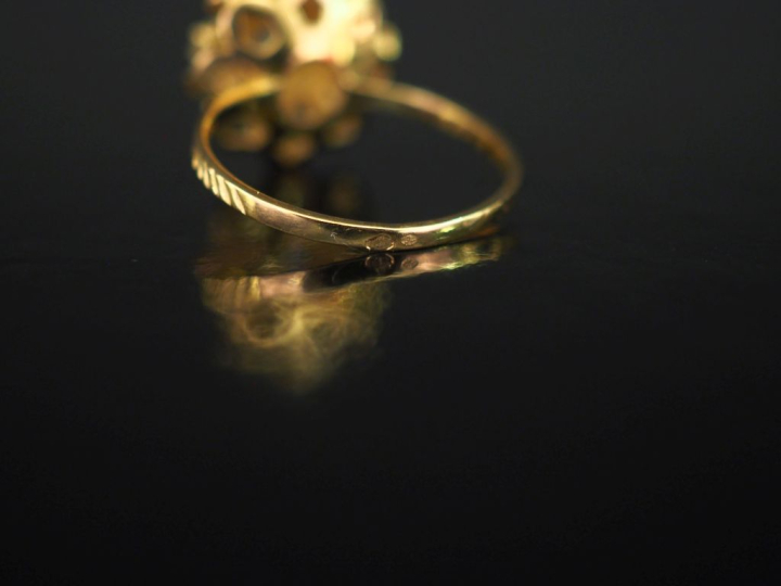 Bague en or jaune 750, ornée en son centre d'un motif de fleur sertie 