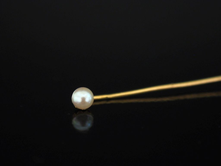 Epingle à cravate en or jaune 750, ornée d'une perle blanche.  Long. 7
