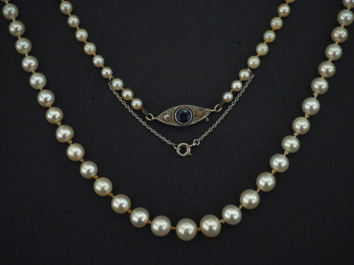 Collier de perles de culture blanches disposées en chute.  Fermoir en 