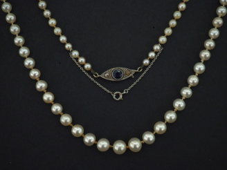 Vente aux enchères Collier de perles de culture blanches disposées en chute.  Fermoir en 