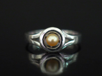 Vente aux enchères Petite bague en or blanc 585, sertie en son centre d'une petite perle 