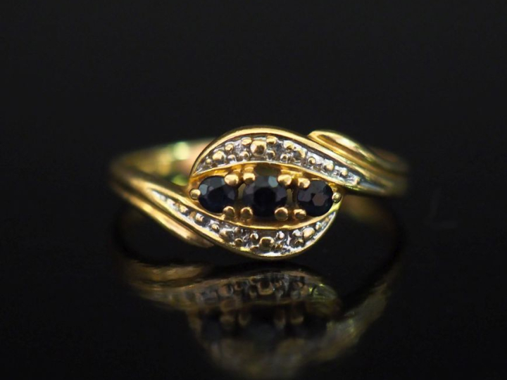 Bague de forme mouvementée en or jaune 750, sertie d'une ligne de troi