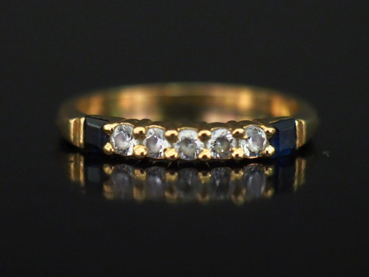 Petite bague jonc en or jaune 750, sertie de cinq pierres à l'imitatio