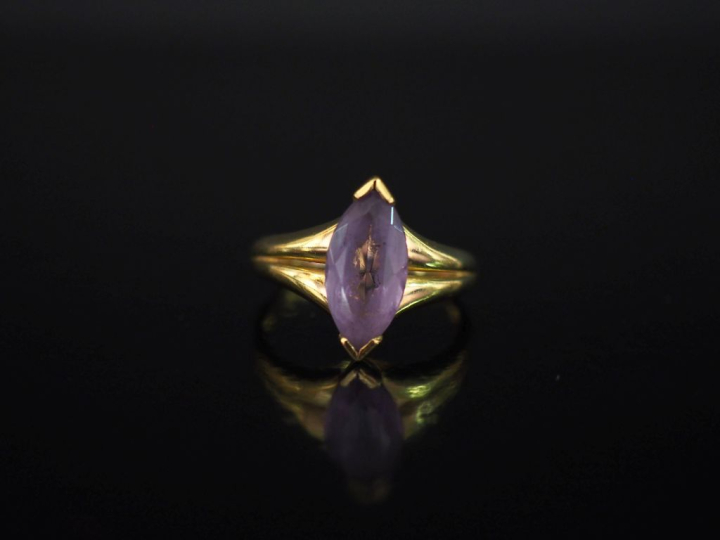 Bague en or jaune 750, sertie en son centre d'une améthyste (?) de for