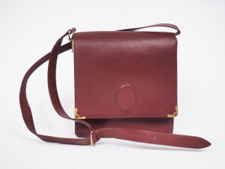 Vente aux enchères CARTIER, Must Sac bandoulière en cuir bordeaux.  Fermeture à rabat et 