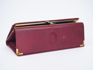 Vente aux enchères CARTIER,  Porte-feuilles en cuir bordeaux.  Signé.  10 x 19 cm (petite